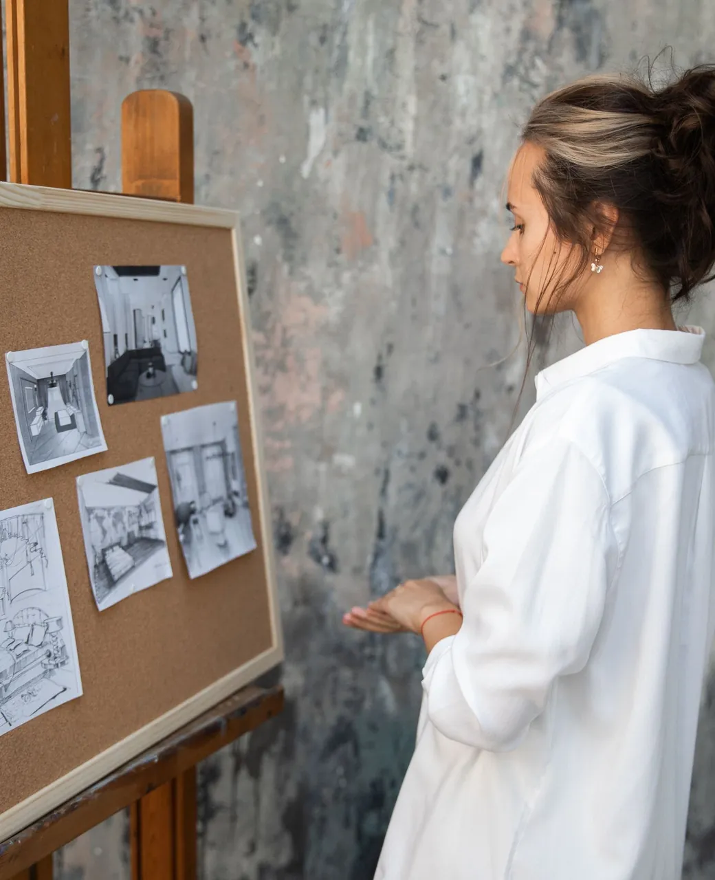 Décoratrice devant un tableau d’inspiration avec croquis et photos d’ambiance