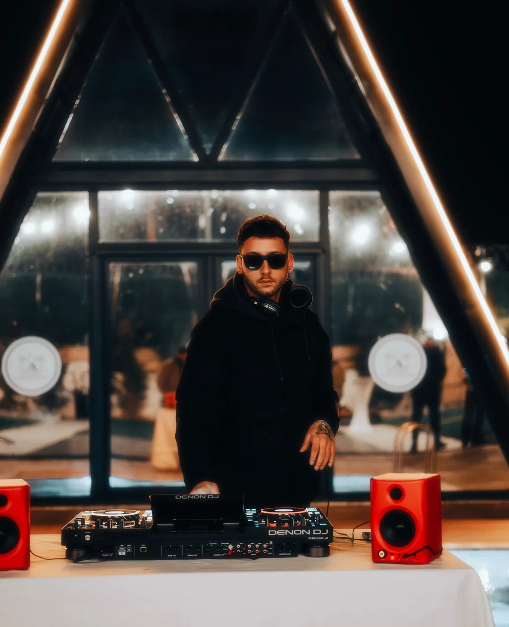 DJ aux platines pendant une réception de mariage sous une structure vitrée