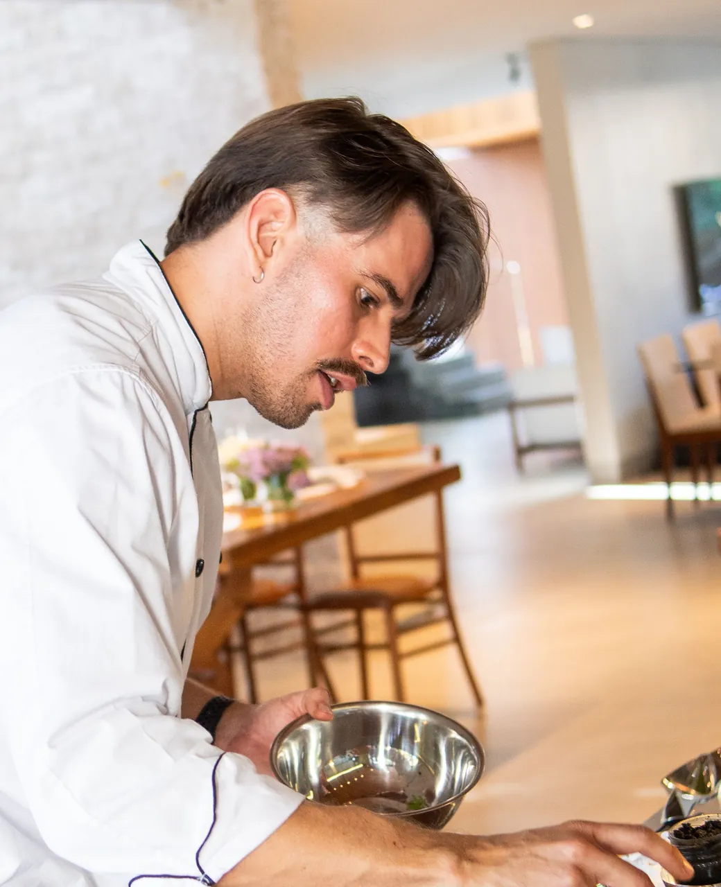 Traiteur en veste blanche dressant des plats sur un buffet de réception